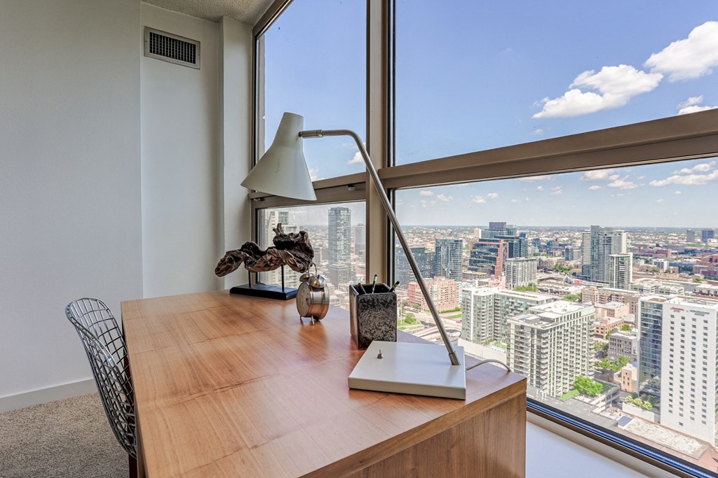 an office desk with a view of the city