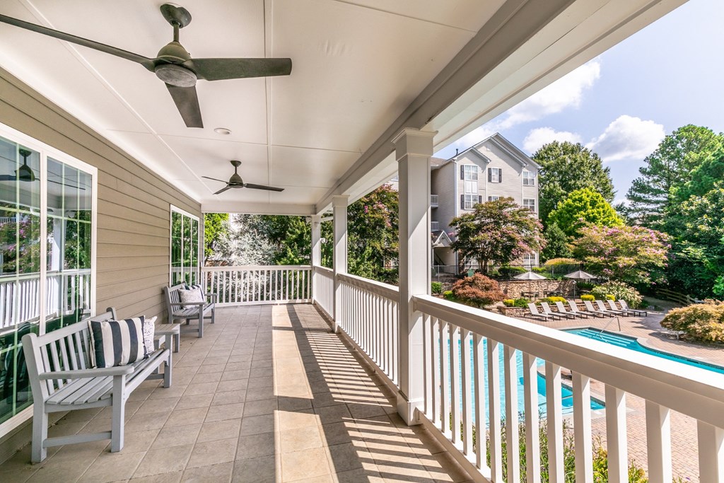 the back porch of a house with a pool and a porch swing