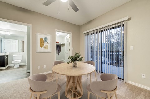 A dining room with a round table and four chairs.