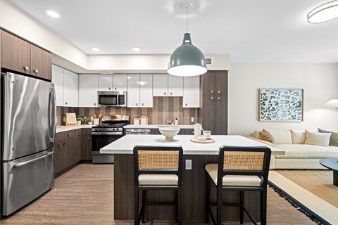A modern kitchen with a dining table set for two.