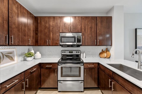 A kitchen with brown cabinets and a stainless steel stove.