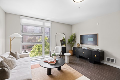 A living room with a white couch and a black coffee table.