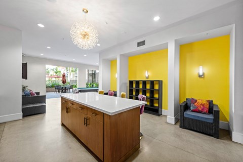 A white kitchen island with a wooden counter and a chandelier hanging from the ceiling.