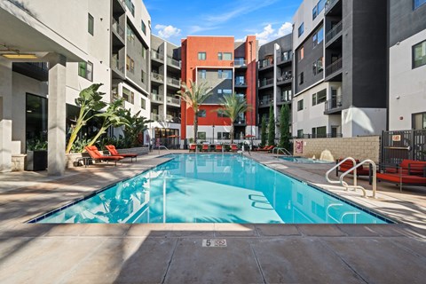 A swimming pool in a courtyard surrounded by buildings.