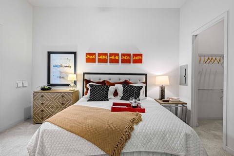 A bedroom with a large bed and a dresser with a mirror.