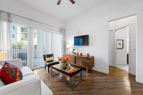 A living room with a white couch and a wooden coffee table.