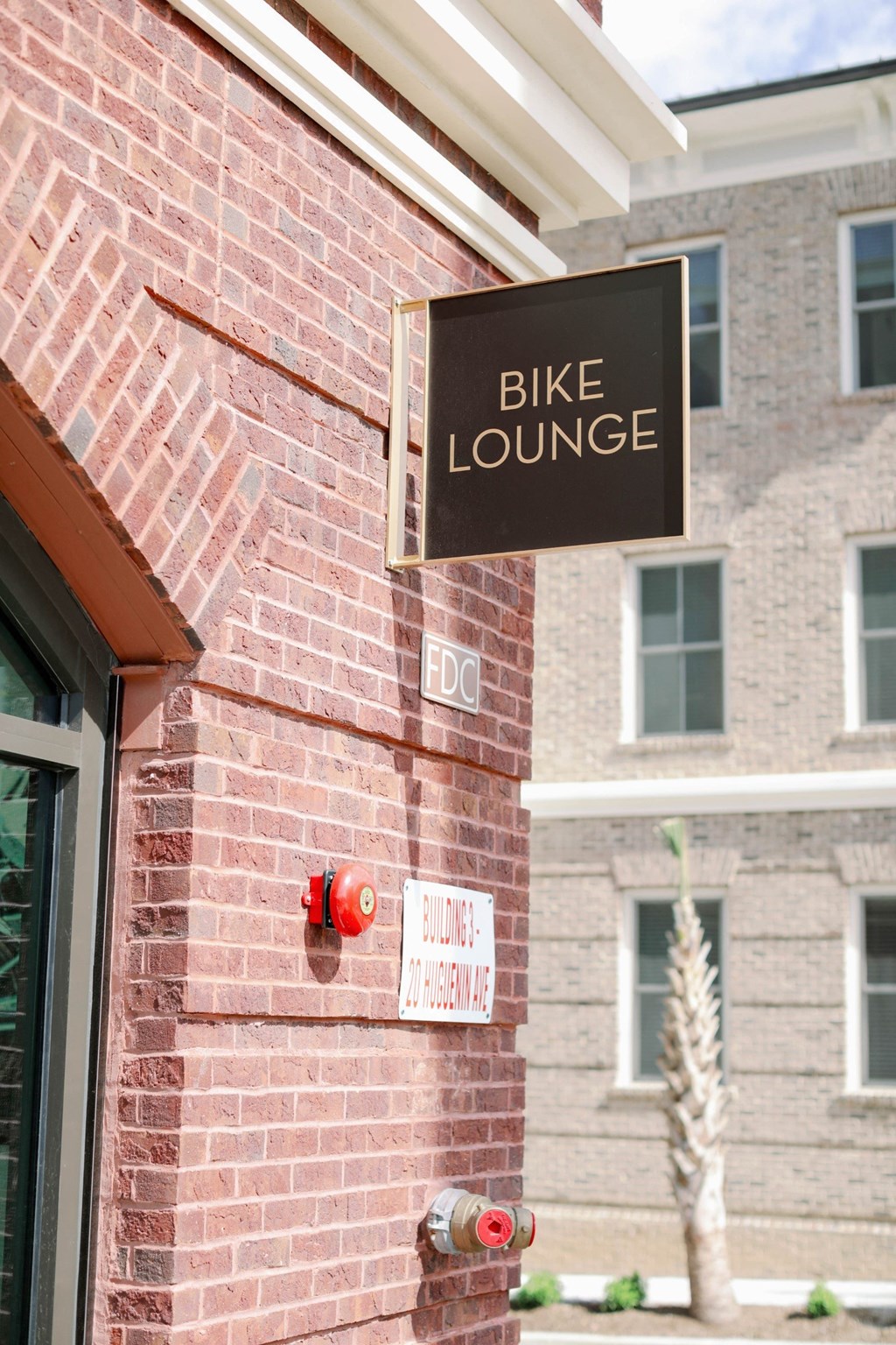 a bike lounge sign on the side of a brick building at The Merchant Apartments, South Carolina 29403