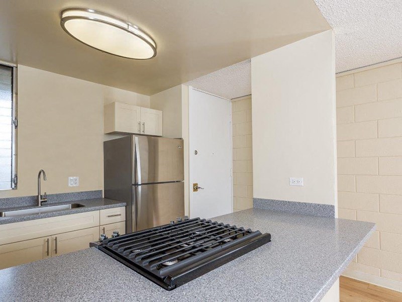 an empty kitchen with a stove and a refrigerator at Palms of Kilani Apartments, Wahiawa