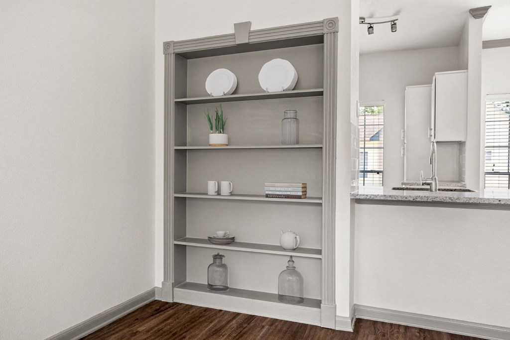 a bookshelf in a living room with a sink and a mirror
