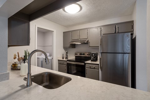 full kitchen with stainless steel appliances and granite countertops at the flats at obsidian