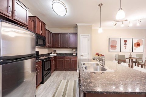 A kitchen with brown cabinets and a stainless steel refrigerator.