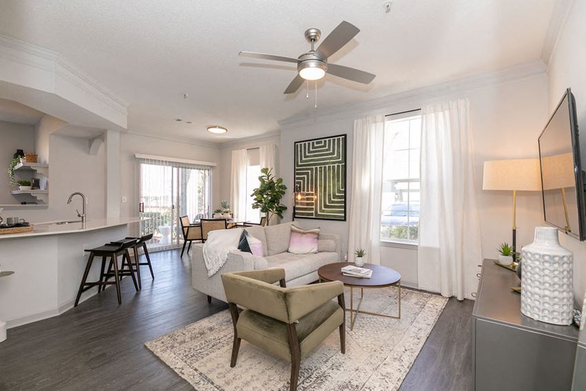 a living room with white walls and a ceiling fan