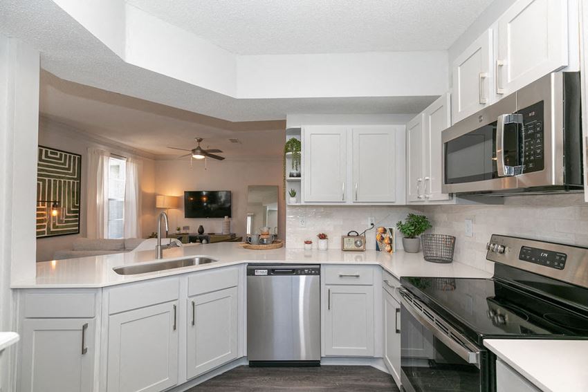 a kitchen with white cabinets and stainless steel appliances