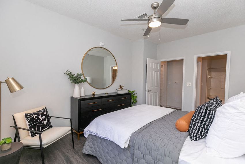 a bedroom with a bed and a dresser with a mirror on top of it