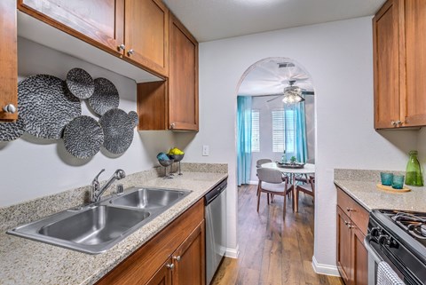 a kitchen with wooden cabinets and a stainless steel sink