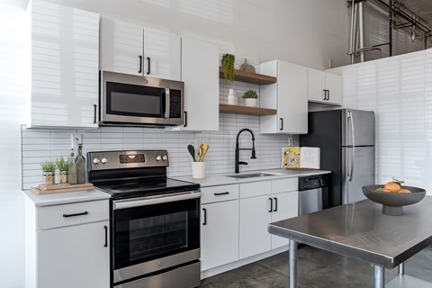 The Mill House floor plan with a modern kitchen with a stainless steel oven and microwave at Highland Mill Lofts in Charlotte, 28205