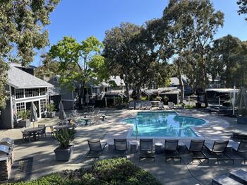 a swimming pool with chairs around it in a courtyard