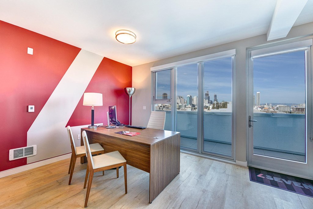 a home office with a desk and a view of the city at L Seven, CA 94103