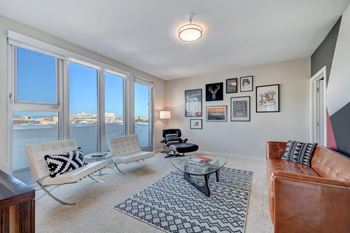a living room with large windows and a leather couch at L Seven, California, 94103