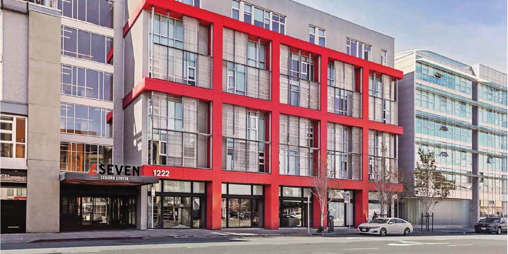 A building with red accents and L Seven logo at L Seven Apartments in San Francisco, CA