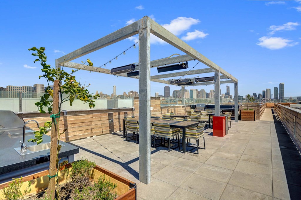 a rooftop patio with tables and chairs and a view of the city at L Seven, California