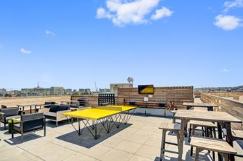 a rooftop patio with tables and chairs and a television at L Seven, San Francisco