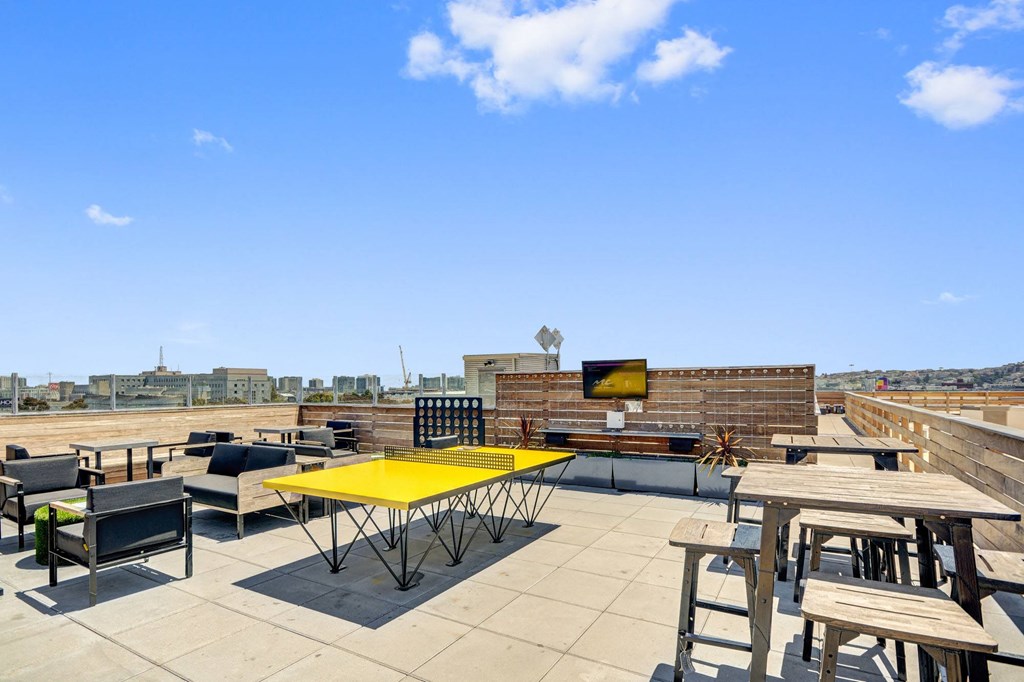a rooftop patio with tables and chairs and a television at L Seven, California