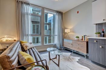 a living room with a couch and a large window at L Seven, CA 94103