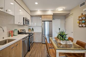 a kitchen with stainless steel appliances and a table with chairs at L Seven, San Francisco, California 94103