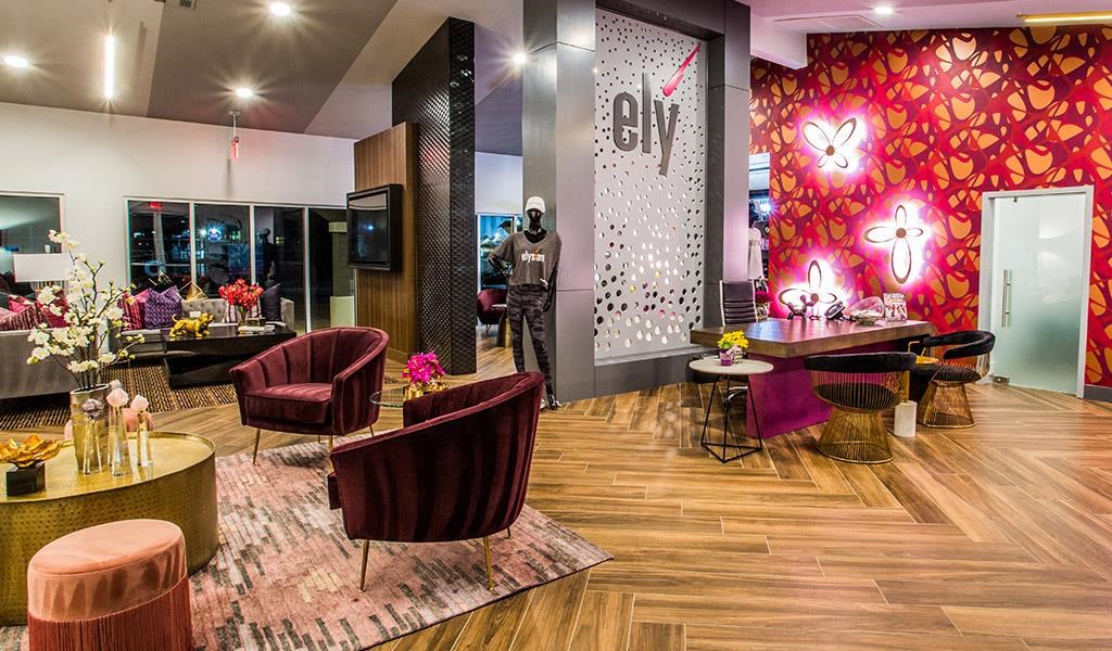 a lobby with chairs and tables and a red wallpaper