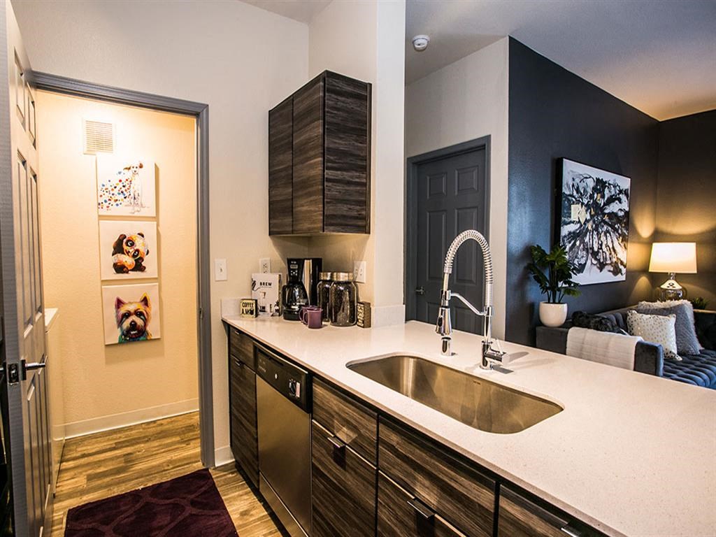 a kitchen with a sink and a door to a living room