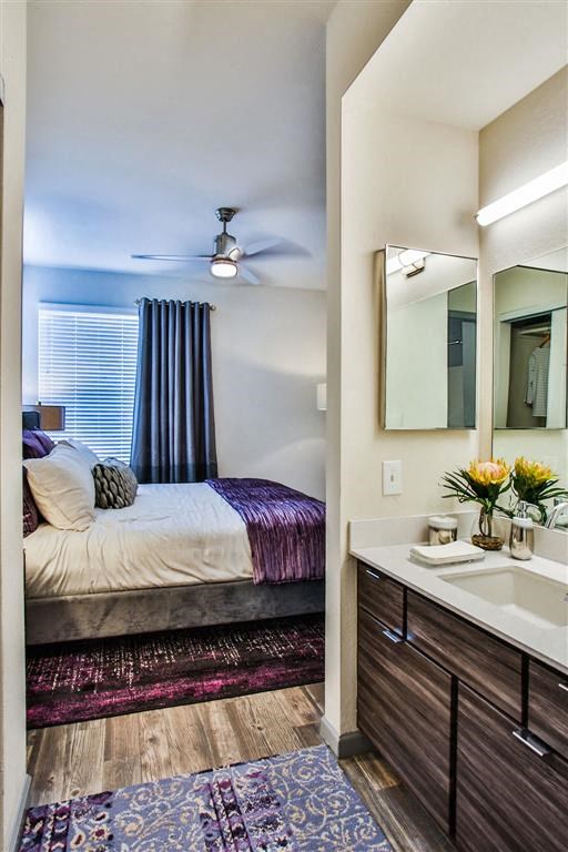 a bedroom with a bed and a sink and a mirror