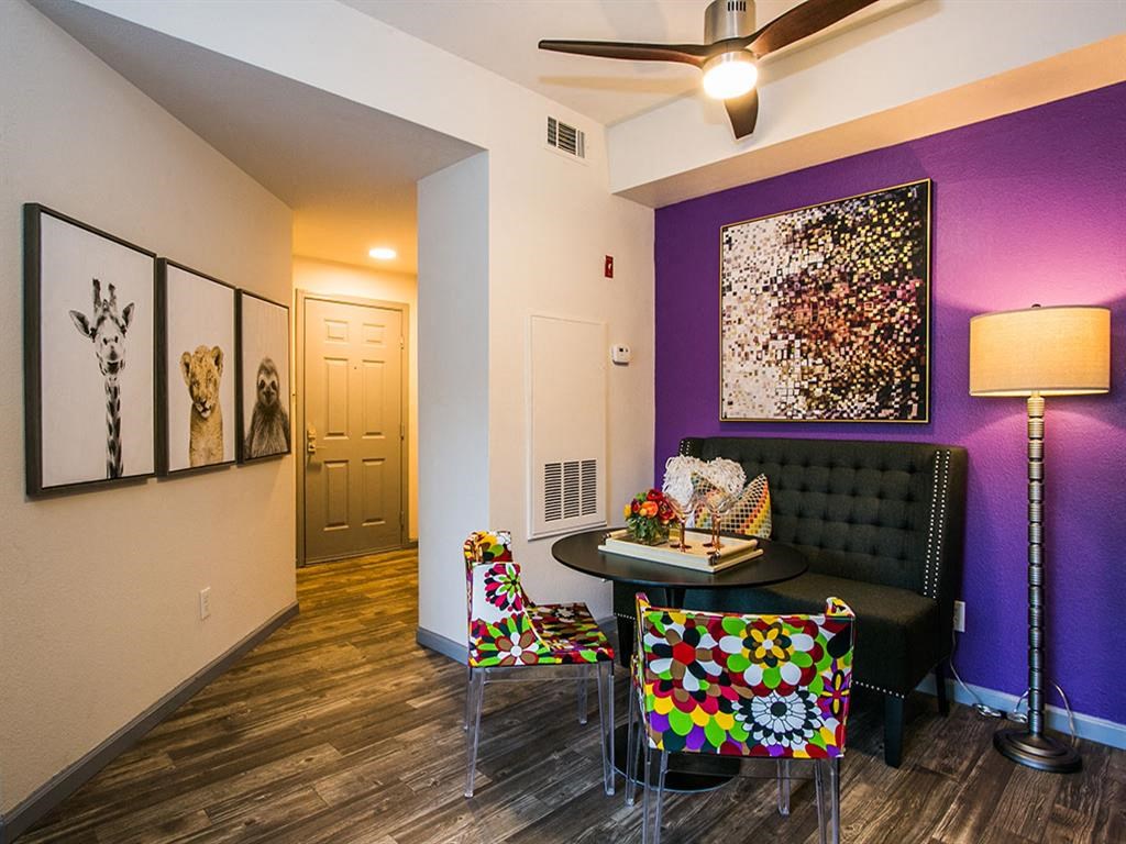 a living room with a purple wall and a table and chairs