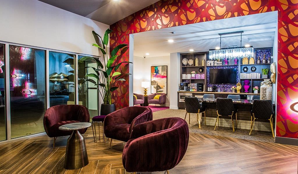 a lobby with chairs and a bar and a large mirror