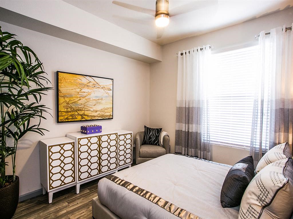 a bedroom with a bed and a couch and a window