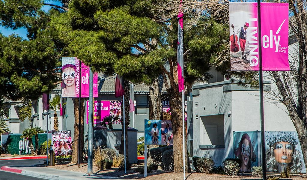 a city street with signs and trees in front of a building