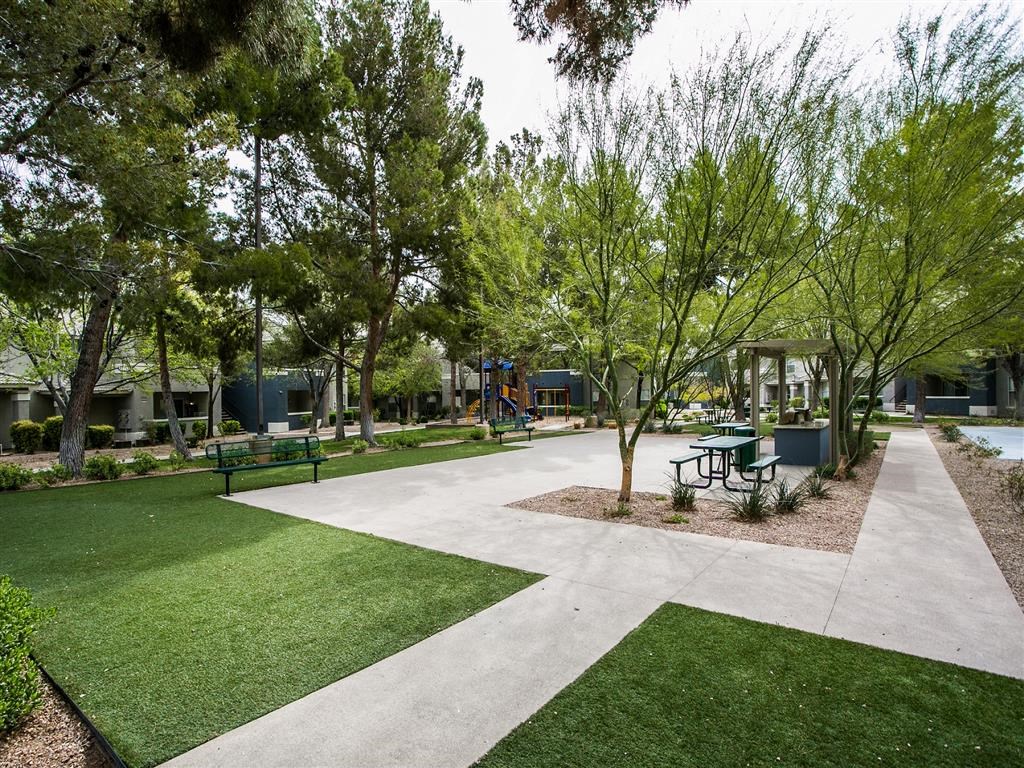 a park with benches and trees and a playground