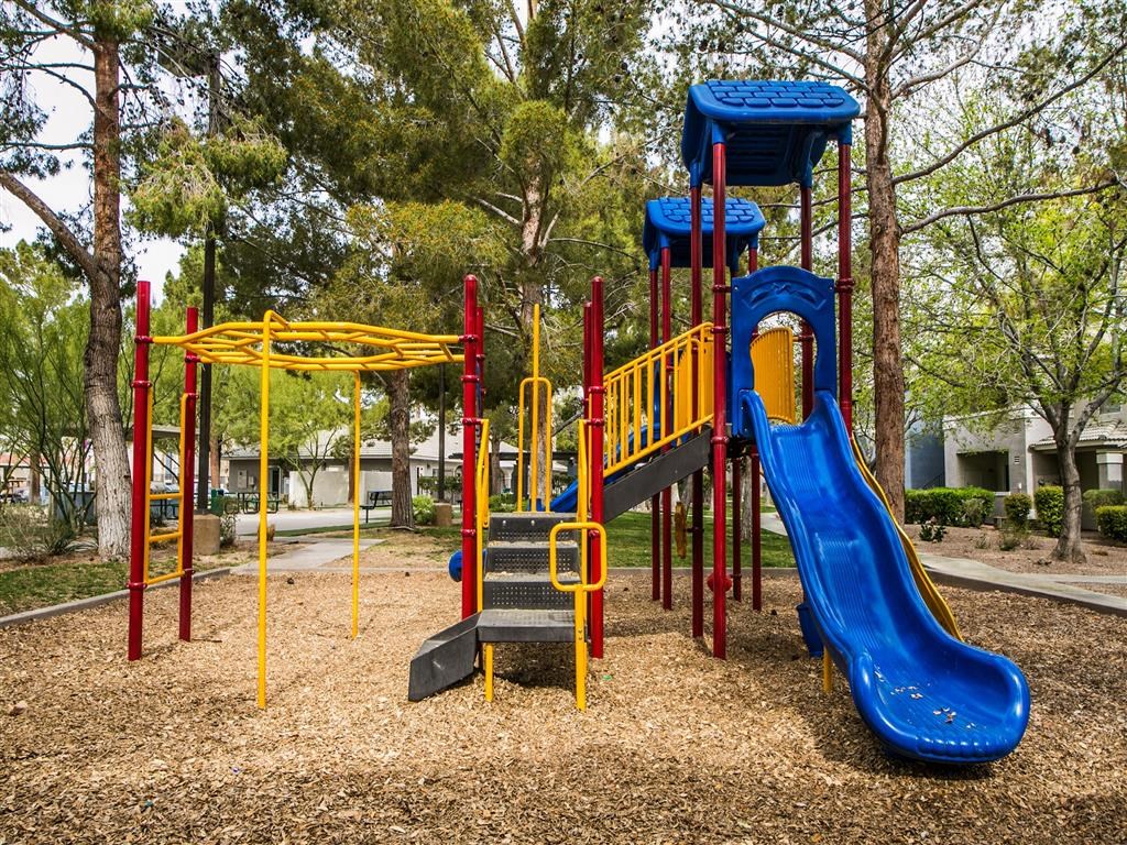 a playground with a blue slide and other playground equipment
