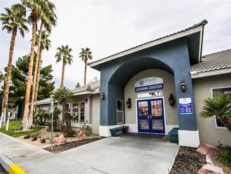 a blue building with a door and palm trees