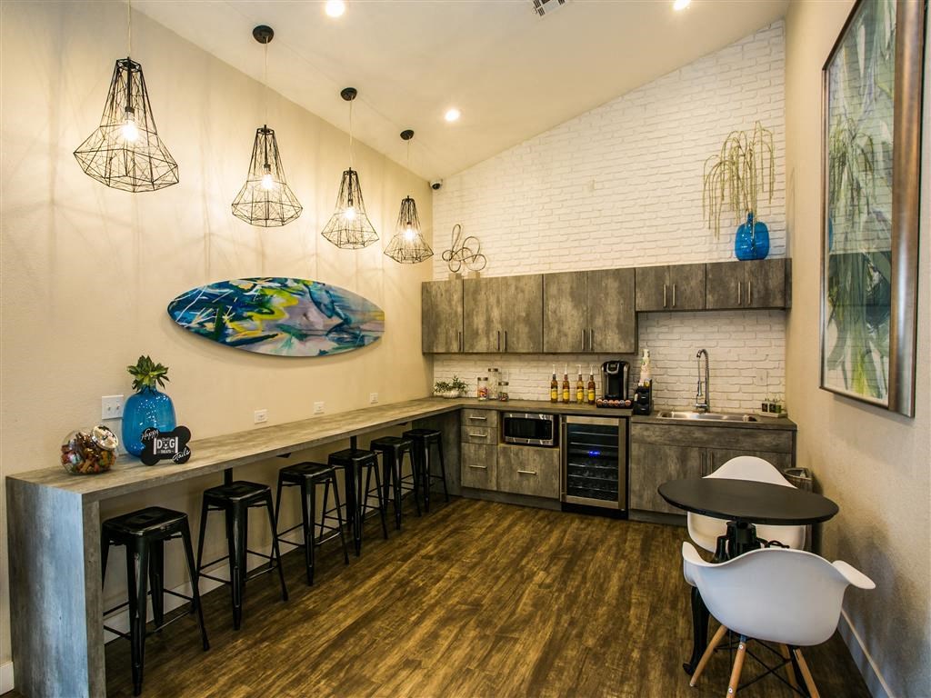 a kitchen with a long counter and a bar with chairs