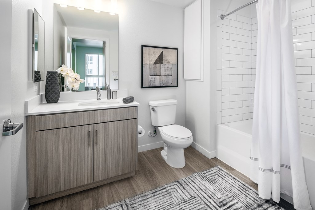 a bathroom with a toilet sink and shower and a mirror