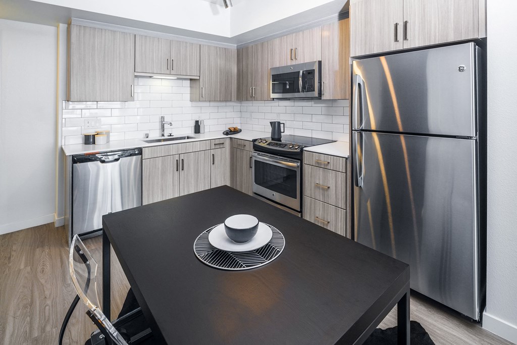 a kitchen with stainless steel appliances and a black table