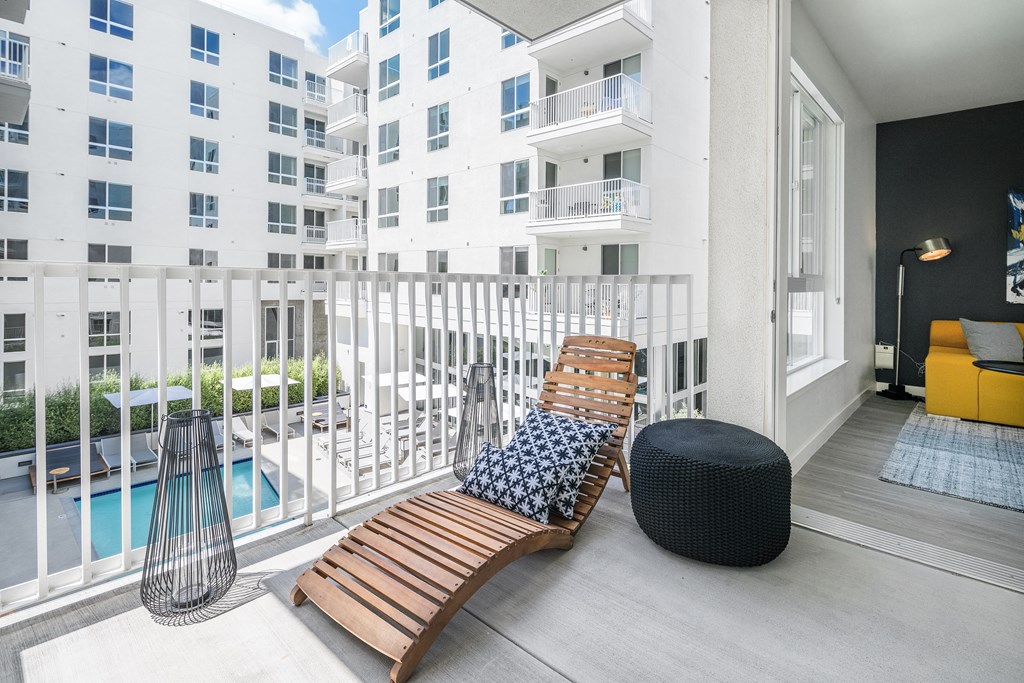 a balcony with two chairs and a bench and a swimming pool