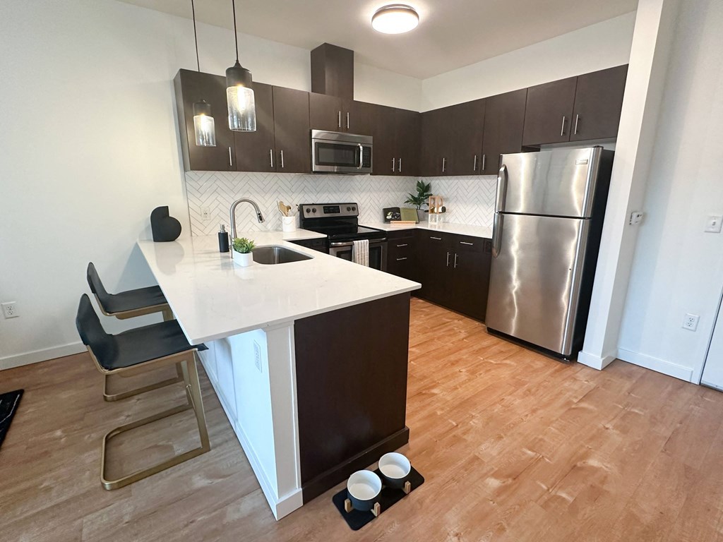 a kitchen with stainless steel appliances and a white counter top at The Parker Apartments, Portland, 97209