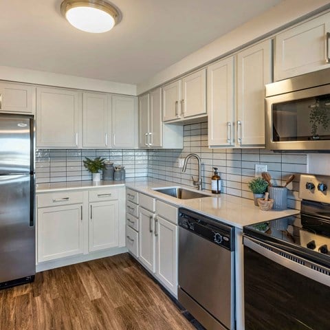 a kitchen with stainless steel appliances and white cabinets at The Rays at Vegas Towers Apartments, Las Vegas, Nevada
