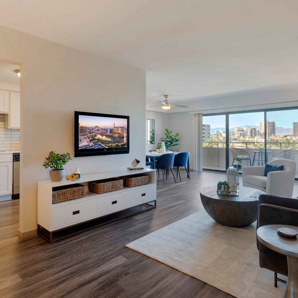a living room with a view of the city and a tv on the wall at The Rays at Vegas Towers Apartments, Las Vegas, NV 89119