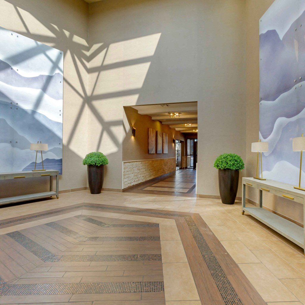 the lobby of a hotel with a view of a hallway with plants at The Rays at Vegas Towers Apartments, Nevada