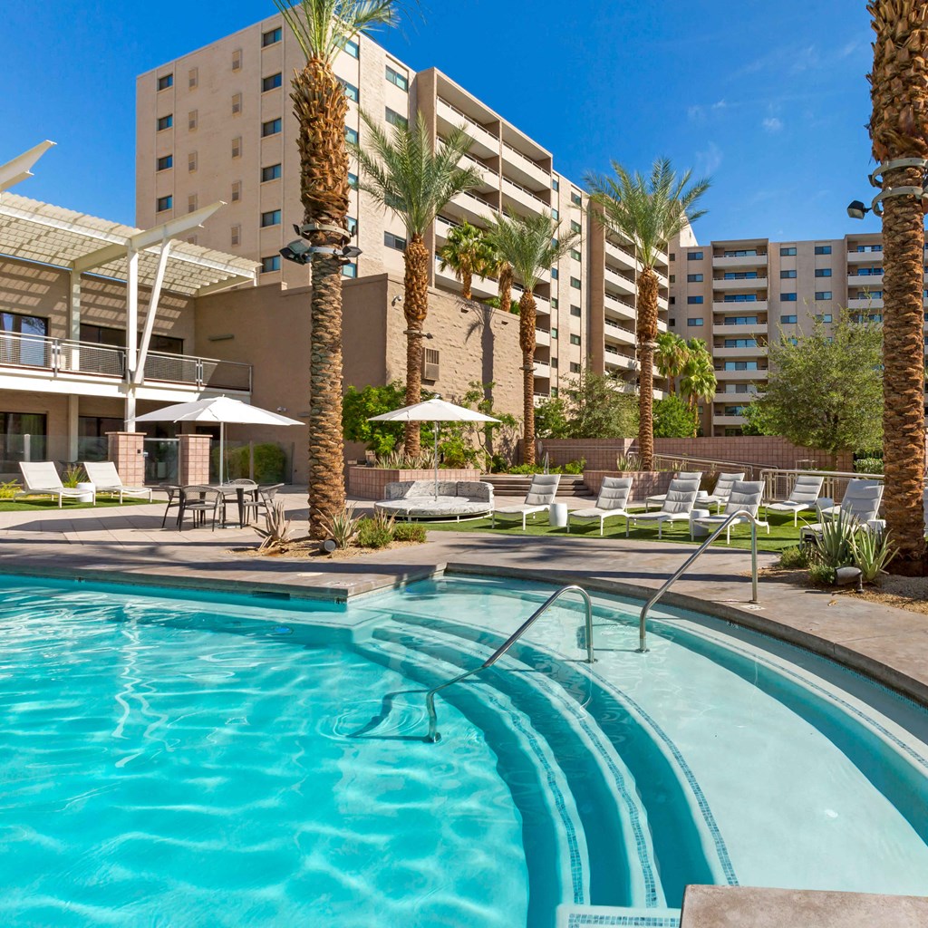 a swimming pool at a hotel with palm trees at The Rays at Vegas Towers Apartments, Nevada