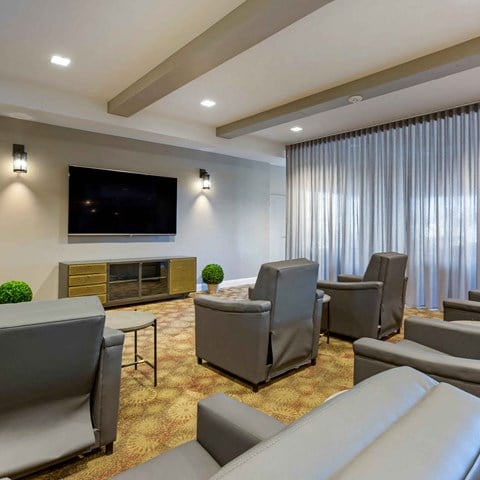 a living room with couches chairs and a television at The Rays at Vegas Towers Apartments, Las Vegas, Nevada