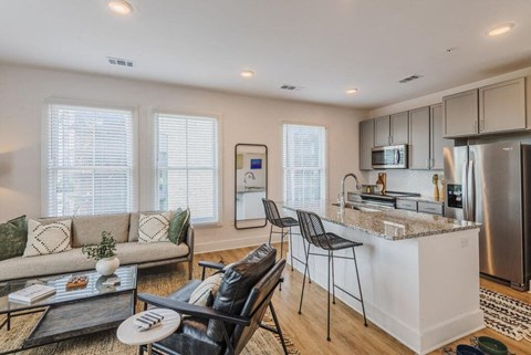 a living room with a kitchen and a table at The Merchant Apartments, Charleston